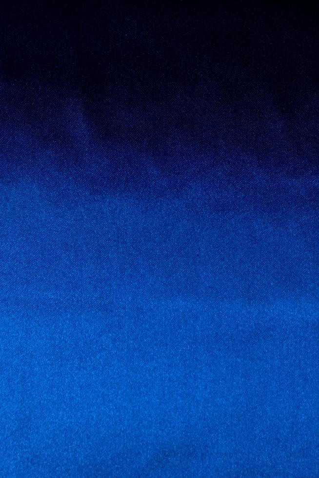 fondo di lusso in tessuto blu scuro. modello di piega ondulata liscia. curva elegante. struttura del materiale in velluto di seta. foto