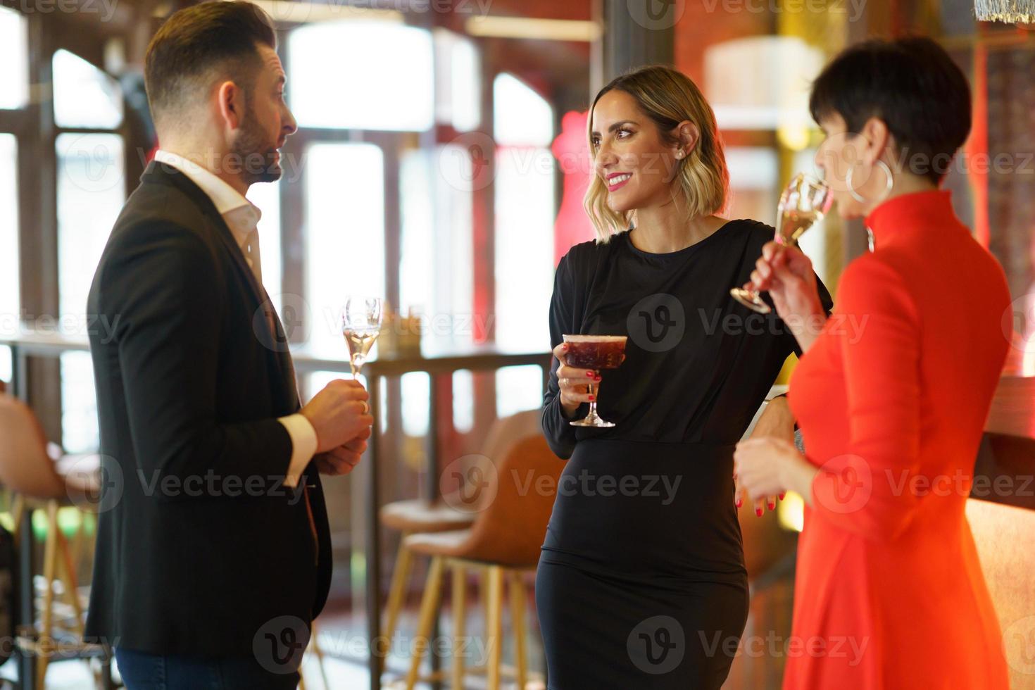 compagnia di amici eleganti che si riuniscono al bar foto