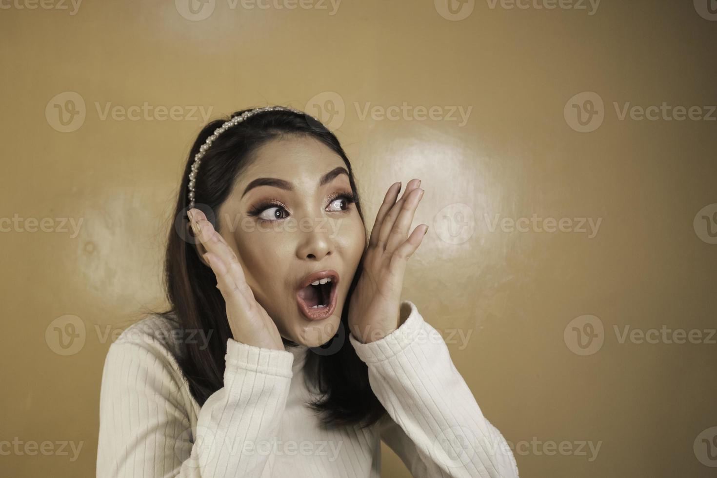 wow e volto scioccato di giovane donna asiatica con gesto di mano aperta. concetto di modello pubblicitario. foto