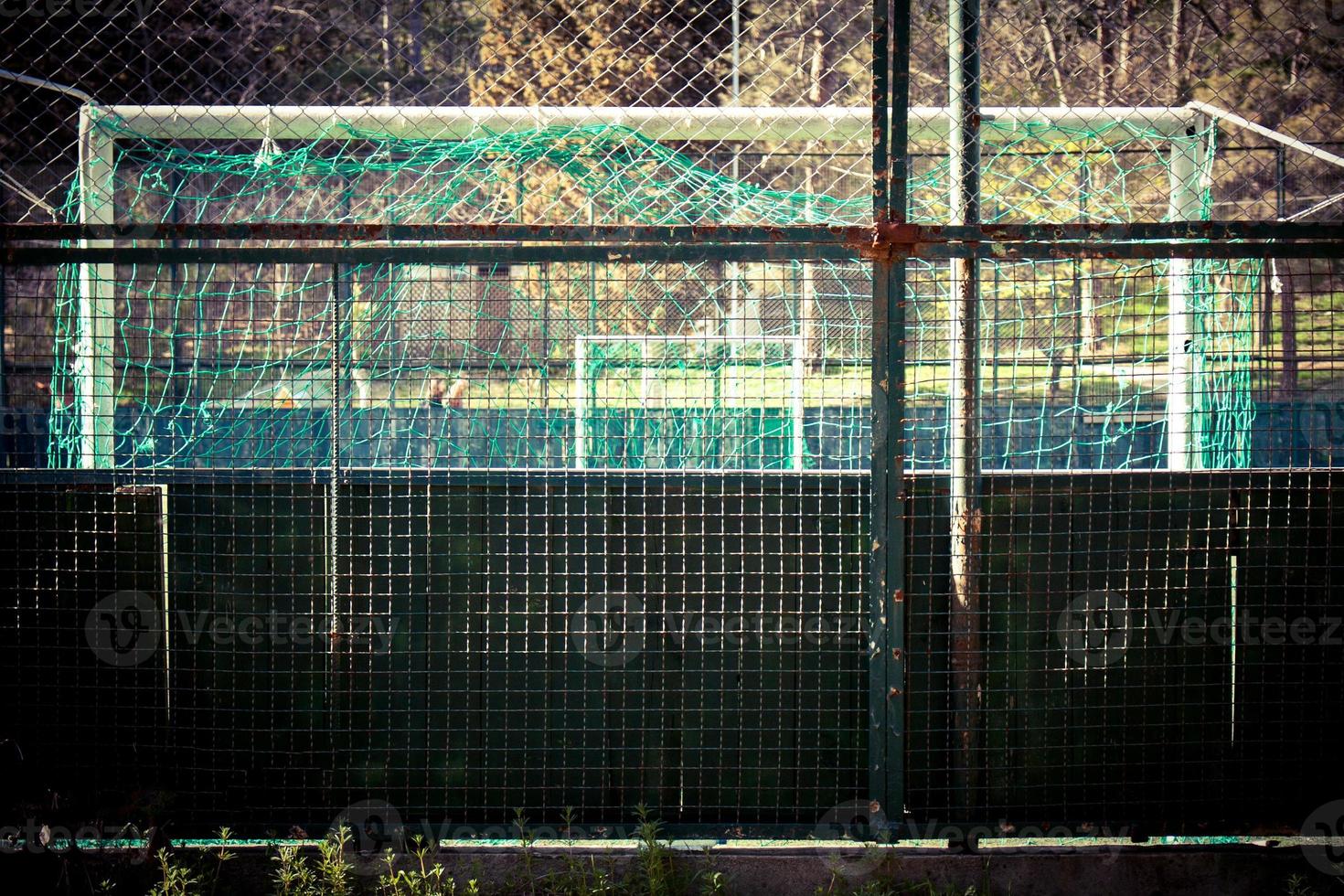 un piccolo stadio circondato da una recinzione metallica verde. foto