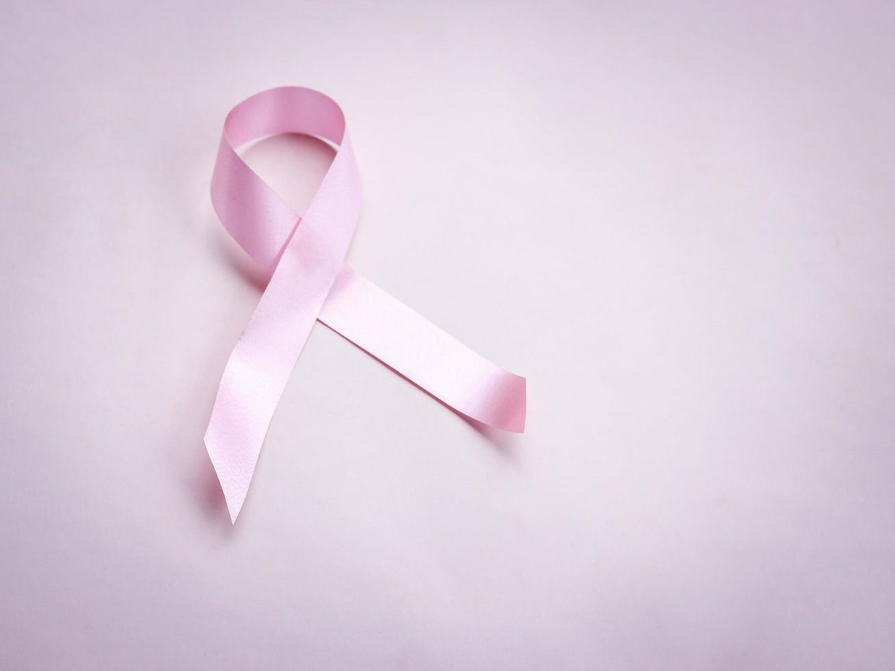 nastro rosa di consapevolezza del cancro al seno su sfondo rosa, simbolo di ottobre, concetto di assistenza sanitaria e medicina foto