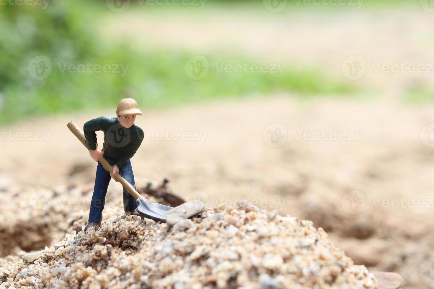 bambola lavoratore in miniatura che tiene pala per il lavoro, minatore uomo al lavoro piccola figura giocattolo modello scavando terreno o giardinaggio foto