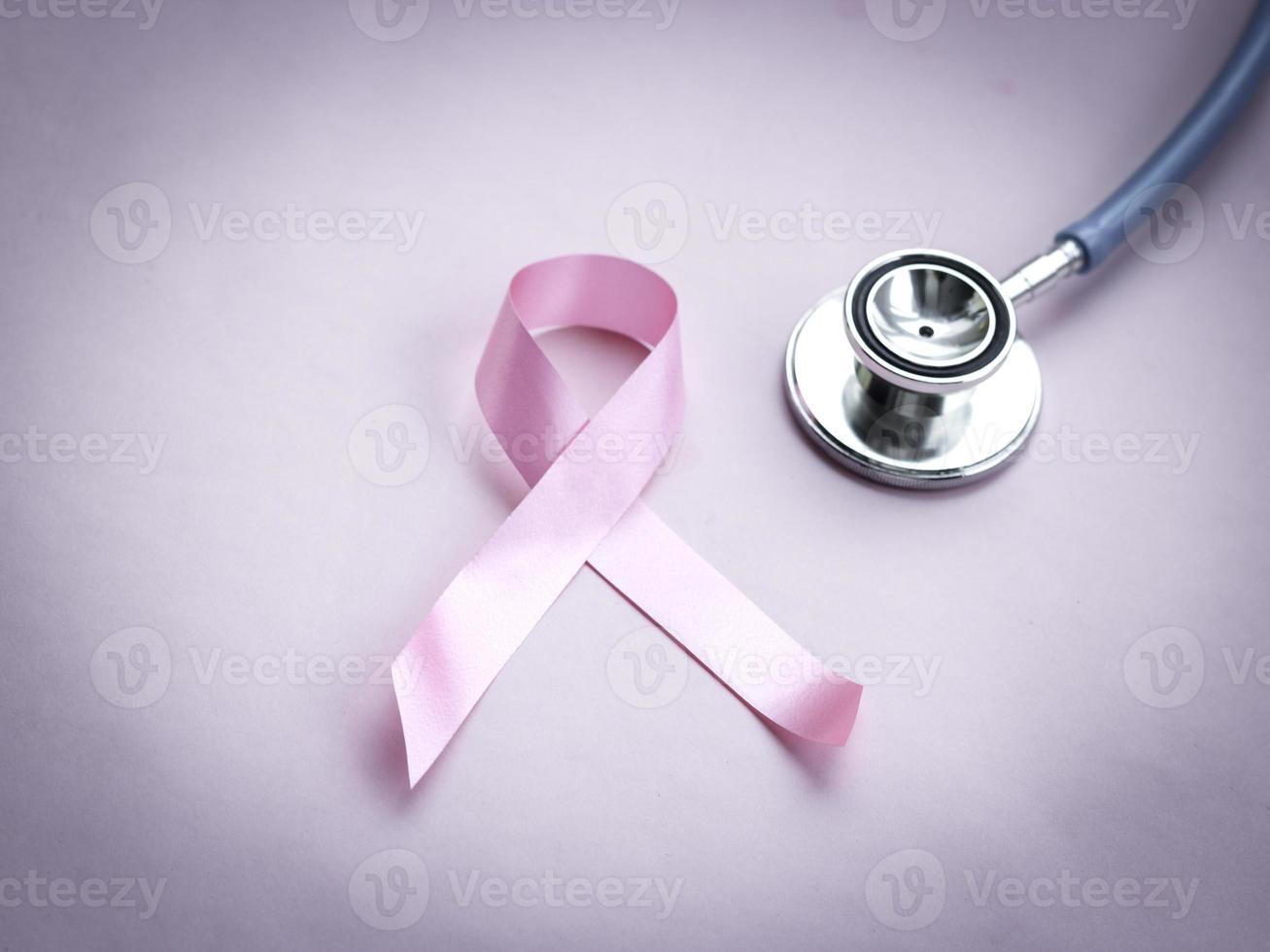 nastro rosa di consapevolezza del cancro al seno con stetoscopio medico su sfondo rosa, simbolo di ottobre, concetto di assistenza sanitaria e medicina foto