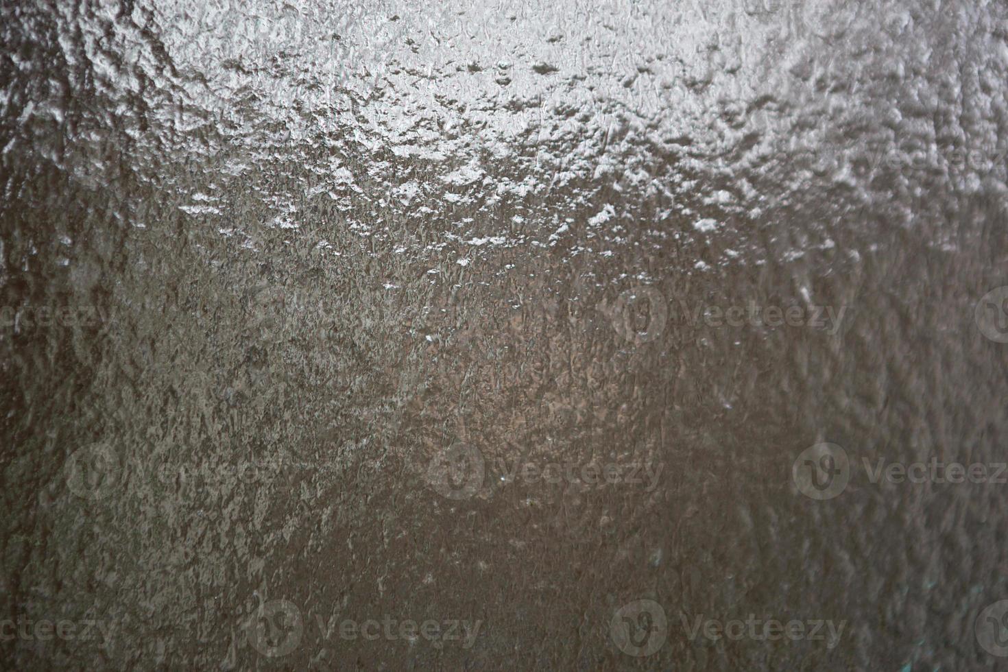 acqua gelata sulla finestra. il vetro trasparente con ghiaccio è traslucido, pioggia gelata. parabrezza dell'auto dopo la pioggia - sicurezza stradale in inverno, nessuna visibilità. sfondo foto