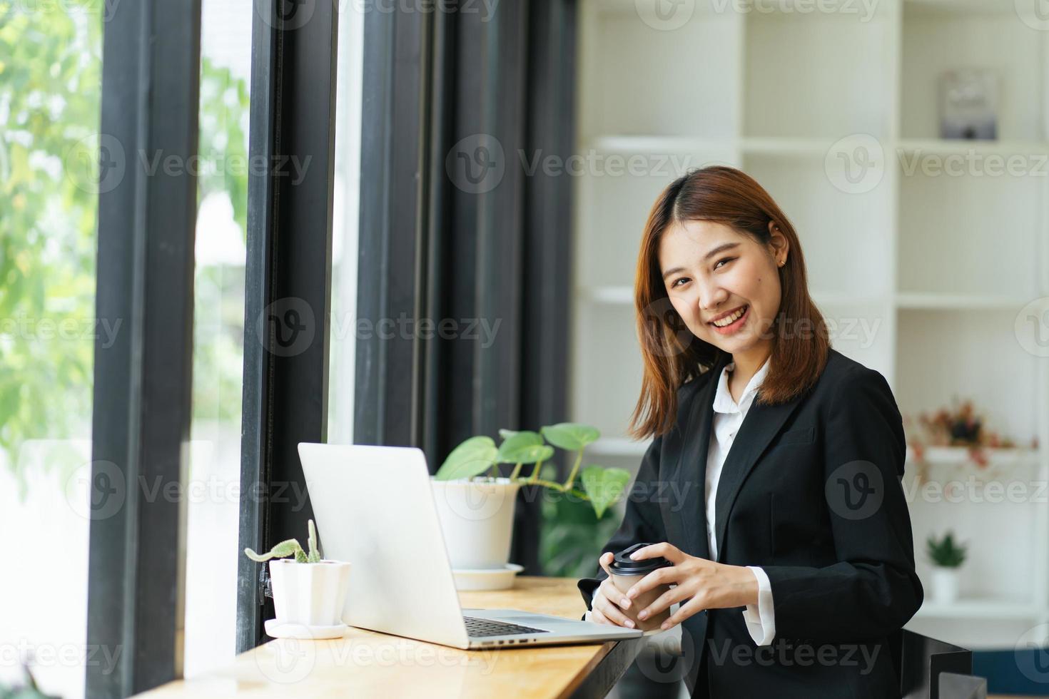 bella giovane donna di affari asiatica sveglia nel caffè, usando il computer portatile. foto