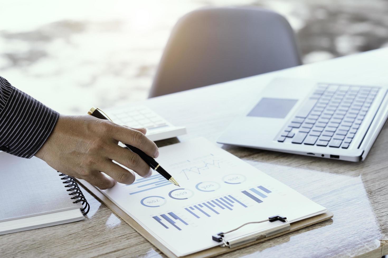 primo piano del contabile o del banchiere che controlla i risultati degli investimenti, calcola i risparmi finanziari, calcola le tasse annuali e i concetti economici. concetto di calcolo finanziario. foto