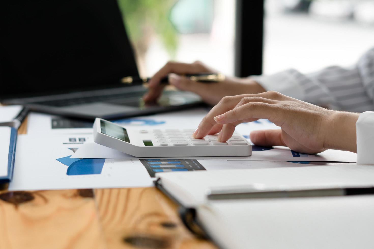 vista ravvicinata delle mani del contabile o dell'ispettore finanziario che fanno report, calcolano o controllano il saldo. finanze domestiche, investimenti, economia, risparmio di denaro o concetto assicurativo. foto