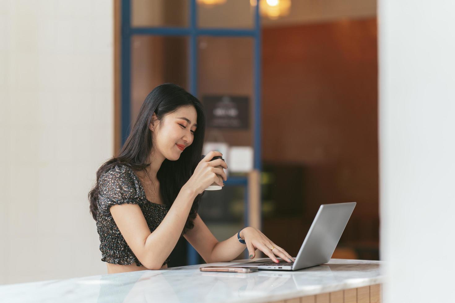 ritratto di giovane donna asiatica che lavora al computer portatile e relazione finanziaria in ufficio. foto