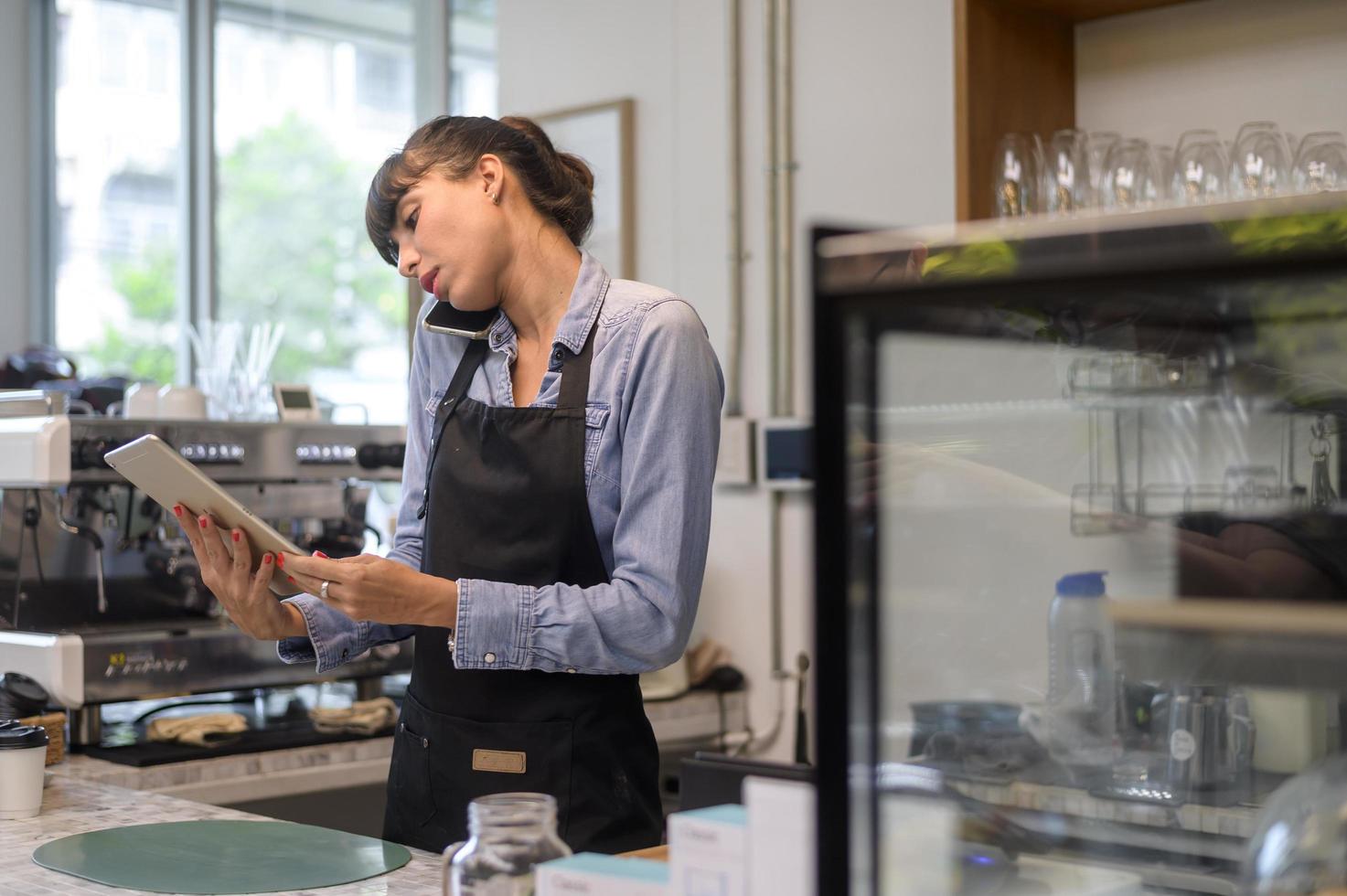 giovane donna barista orientata al servizio che lavora nella caffetteria foto