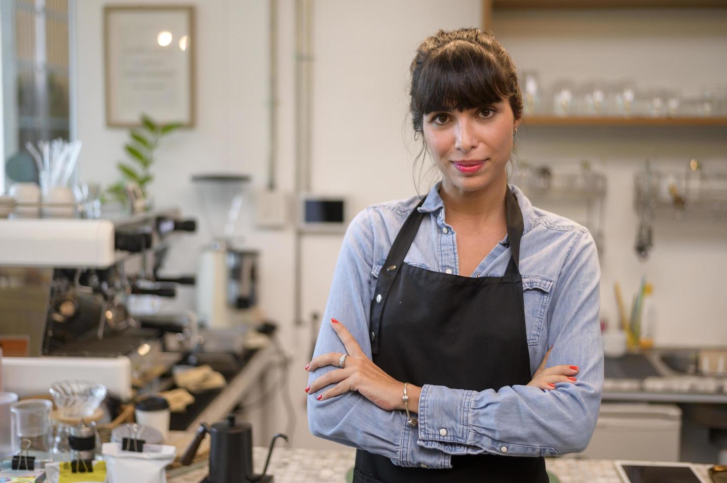 giovane donna barista orientata al servizio che lavora nella caffetteria foto