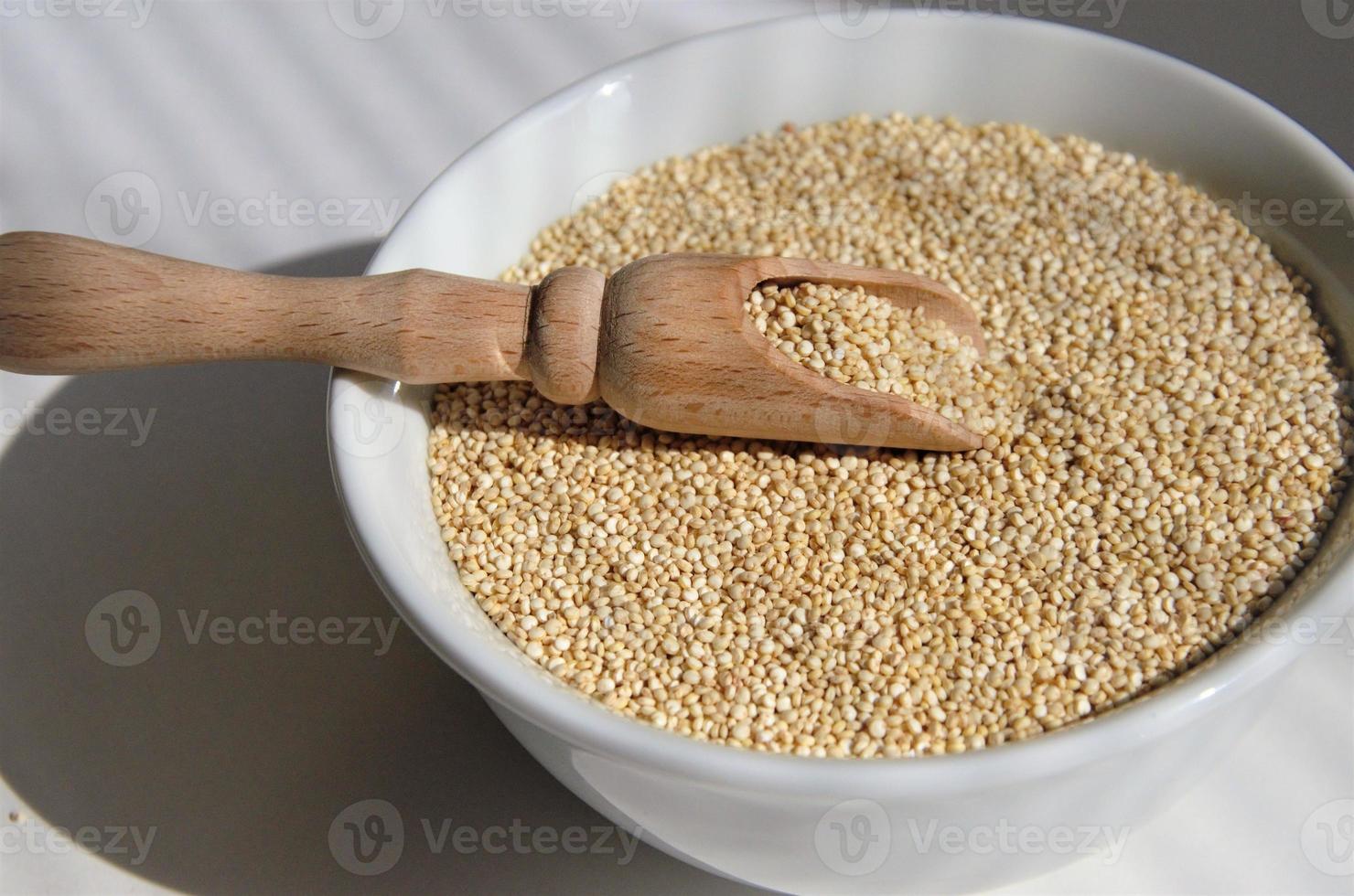 semi di quinoa per mangiare sano in un piatto bianco con un cucchiaio. foto di alta qualità