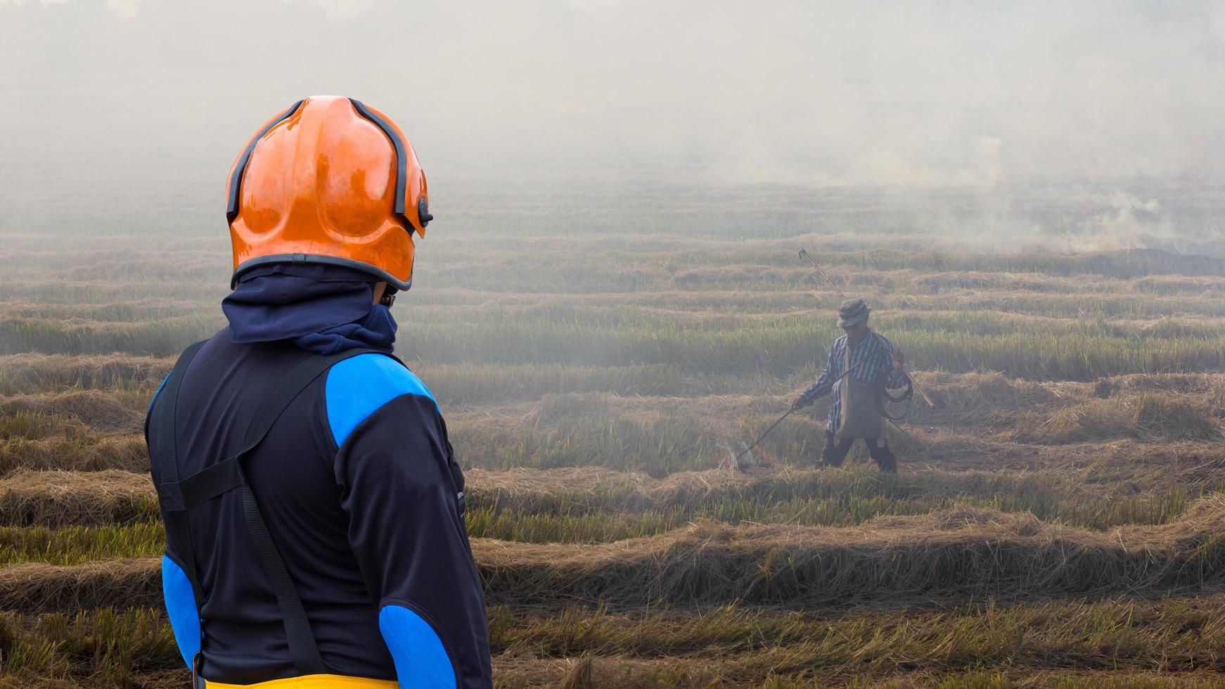 vigili del fuoco con contadini che bruciano paglia. foto