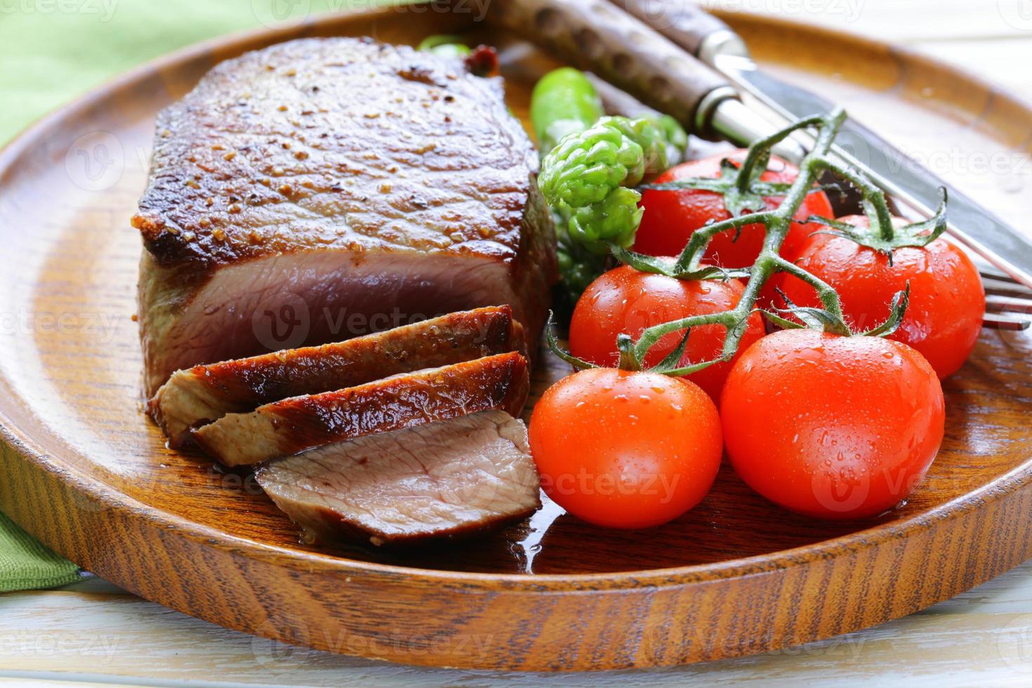 bistecca di manzo alla griglia con contorno di verdure (asparagi e pomodori) foto