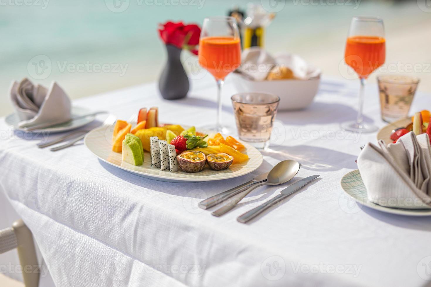 colazione fresca in una splendida posizione con vista sul mare. vacanza estiva di lusso o destinazione per la luna di miele. tavolo con cibo delizioso gourmet vicino al mare con orizzonte. splendida cornice per la colazione estiva foto