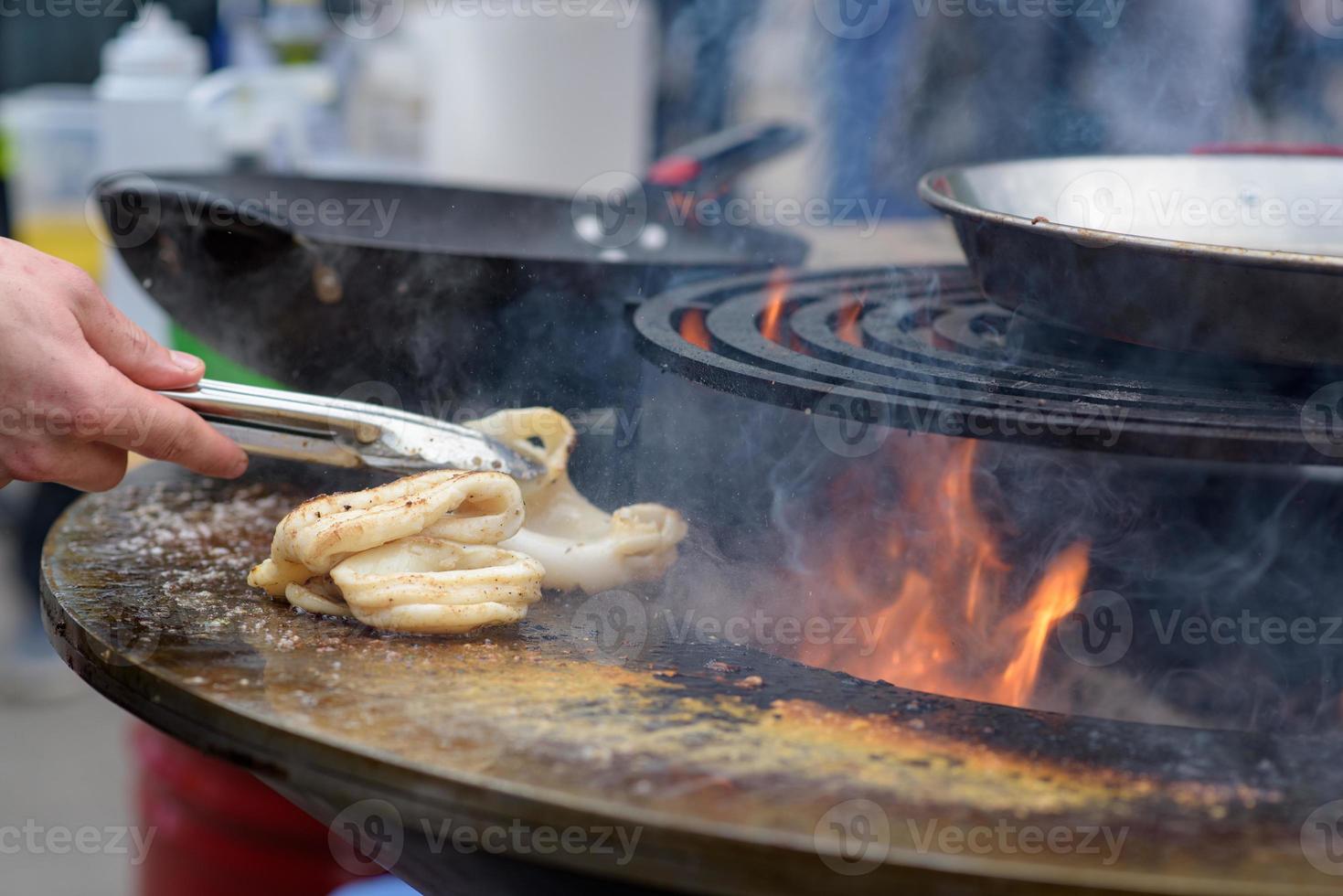 cucinare gamberetti, spiedini di gamberi alla griglia al festival del cibo di strada - primo piano foto