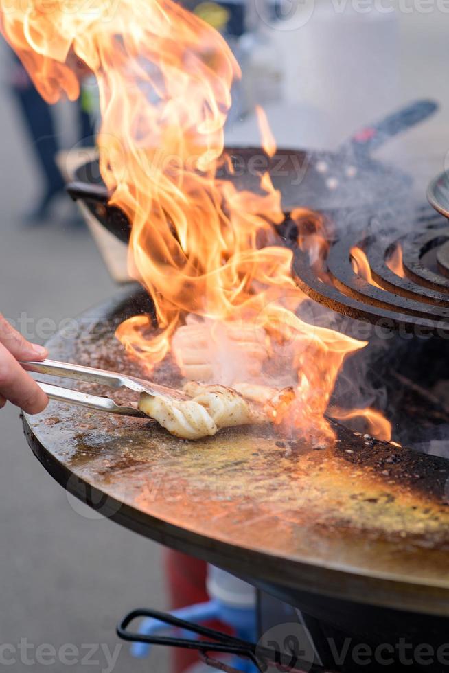 cucinare gamberetti, spiedini di gamberi alla griglia al festival del cibo di strada - primo piano foto