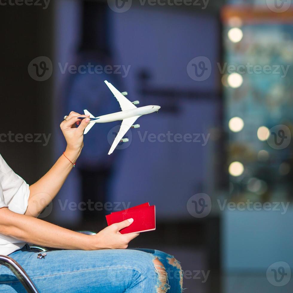 donna felice con aeroplanino modello piccolo all'interno dell'aeroporto foto