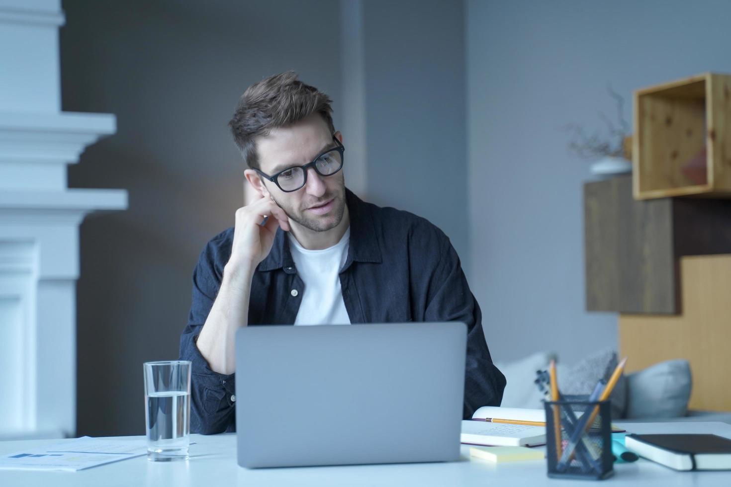 uomo d'affari tedesco concentrato e fiducioso che corrisponde al fornitore del cliente tramite e-mail sul laptop foto