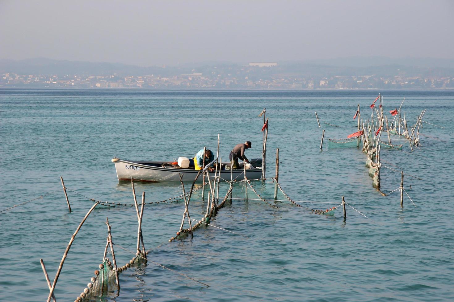 lago di garda, italia, 2006. pescatori che controllano le reti foto