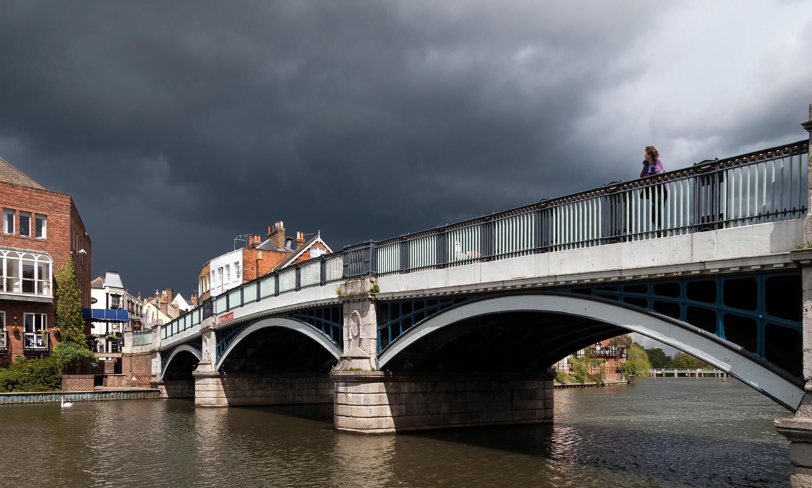 windsor, berkshire, regno unito, 2005. donna che guarda oltre il ponte di eton mentre si avvicina una tempesta foto