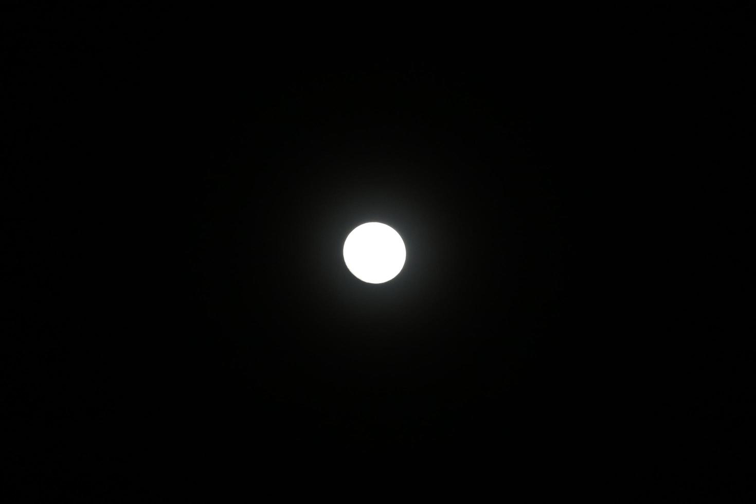 luna piena di notte. forma rotonda bianca su sfondo nero. foto