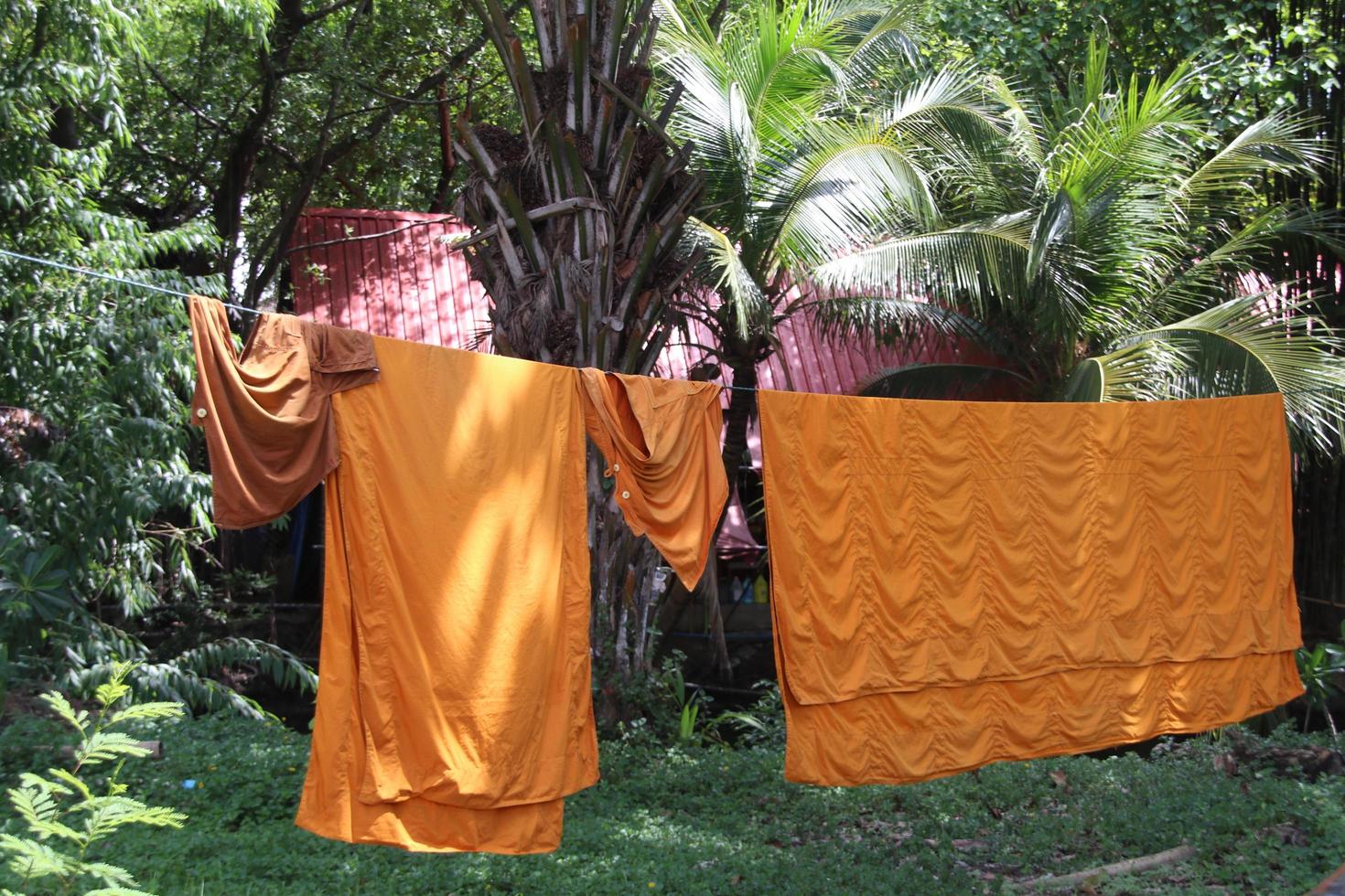 le vesti sono su filo nel tempio e vestiti asciutti al sole, tailandia. foto