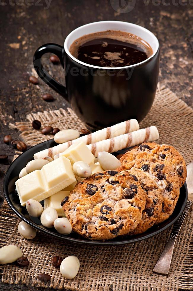 tazza di caffè con cioccolato bianco, mandorle e biscotti foto