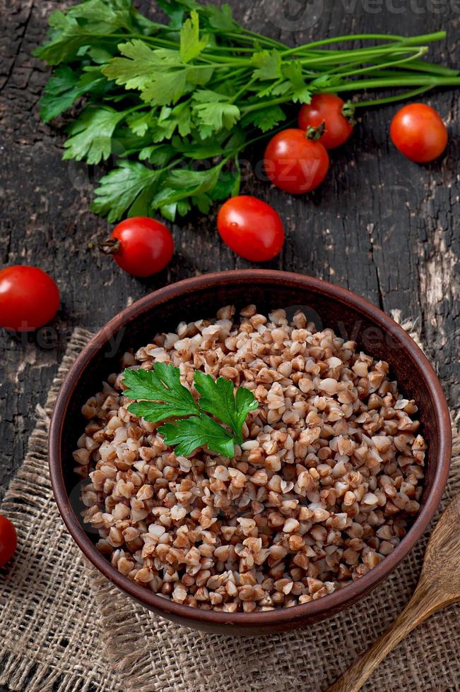 porridge di grano saraceno in una vecchia ciotola di ceramica su uno stile rustico foto