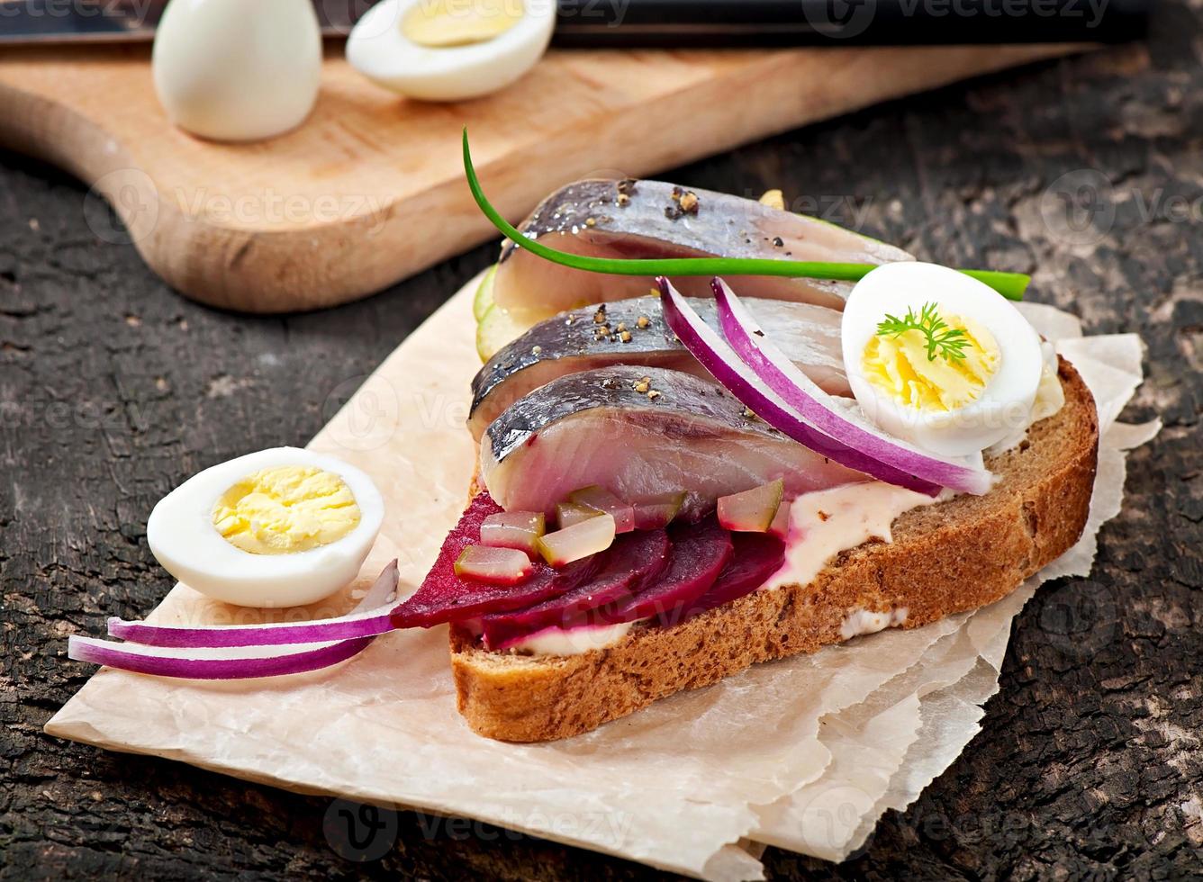 panino di pane di segale con aringhe, barbabietole, cipolle e uova foto