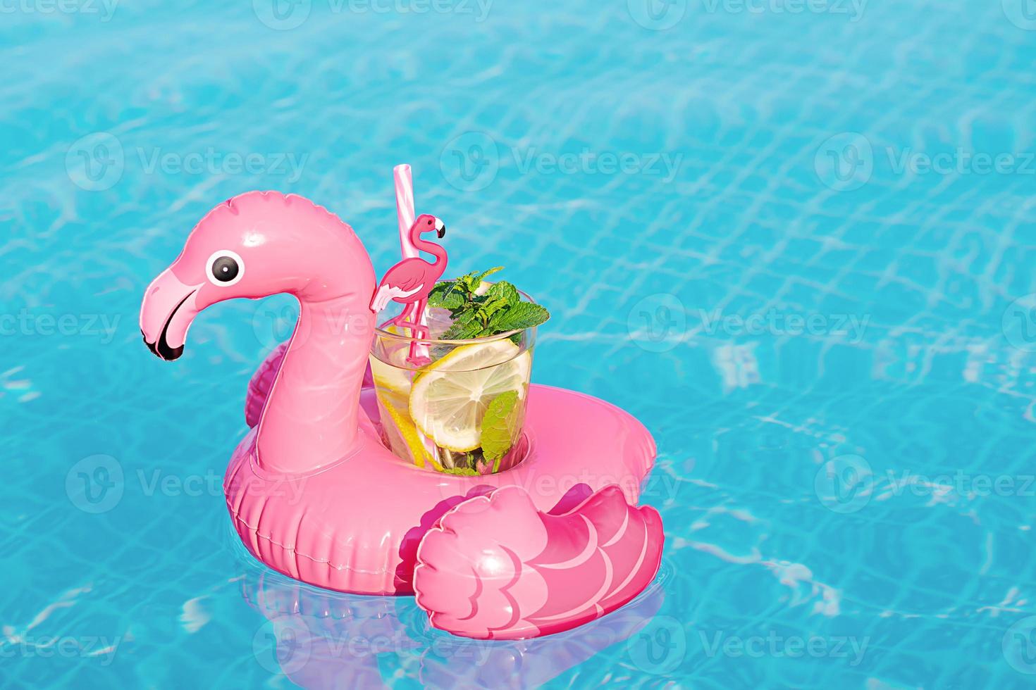 fresco cocktail mojito sul giocattolo gonfiabile del fenicottero rosa in piscina. concetto di vacanza. foto