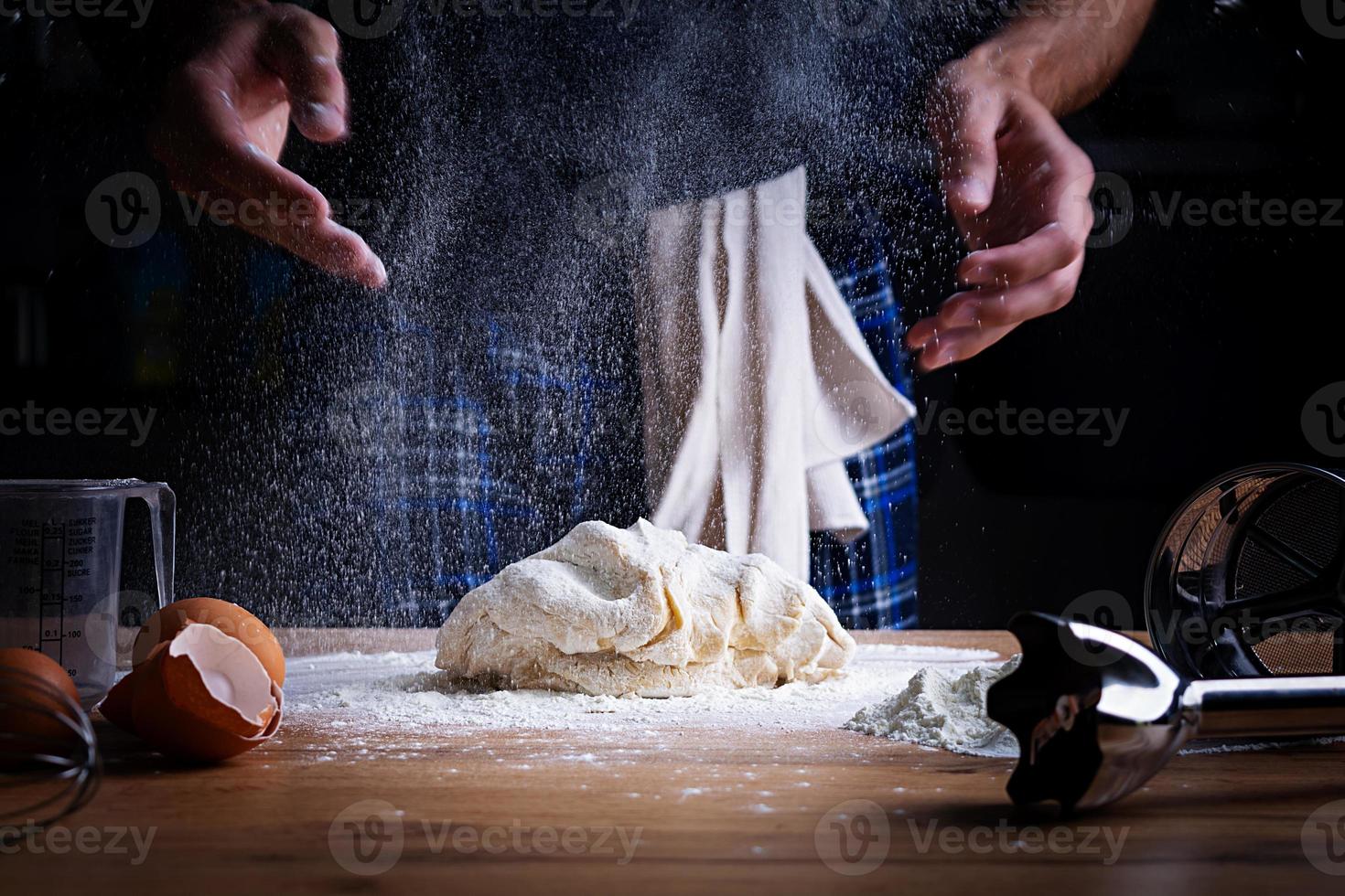 mani maschili che producono pasta per pizza, gnocchi o pane. concetto di cottura. foto