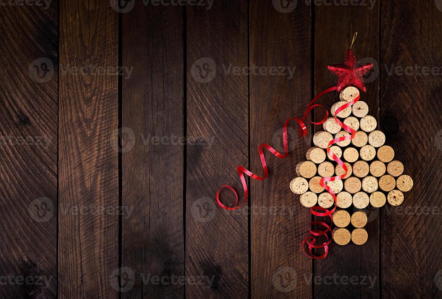 albero di natale fatto di tappi per vino su sfondo di legno. cartolina mockup con albero di natale e copia spazio per il testo. vista dall'alto. foto