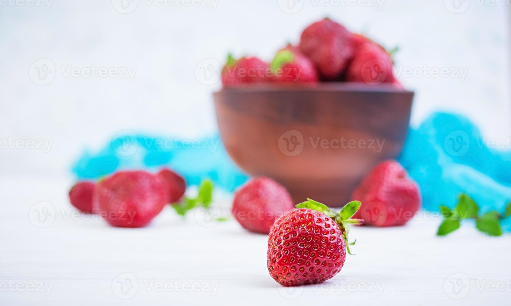 fragola fresca in una ciotola su fondo di legno foto