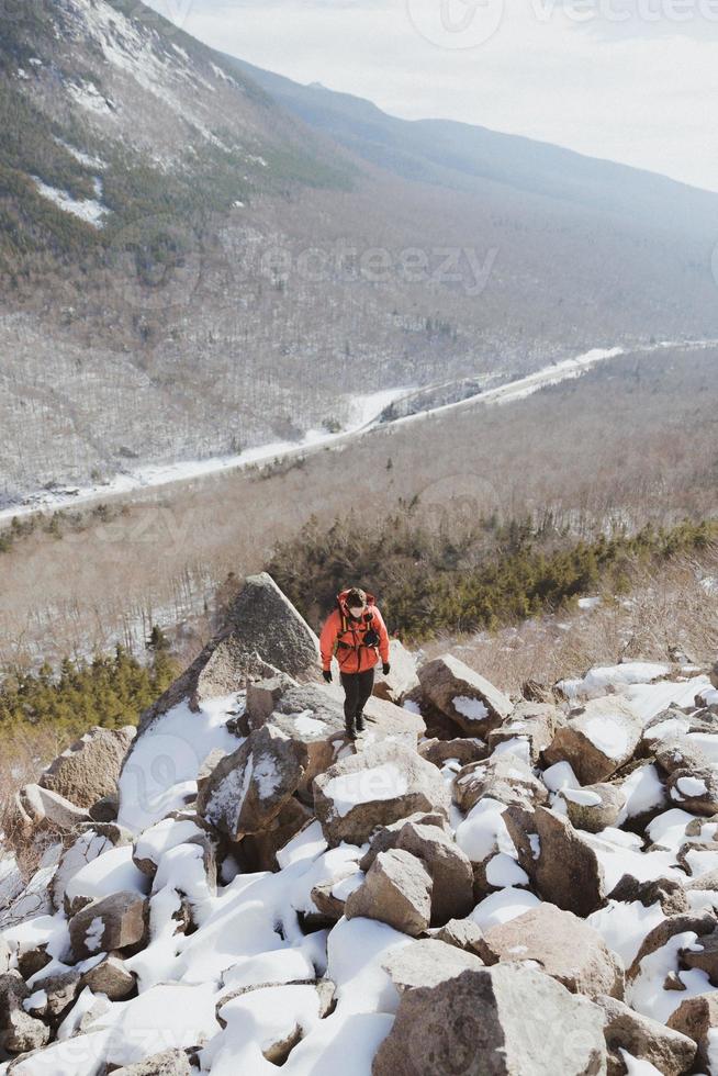 persona che fa un'escursione su una montagna innevata foto