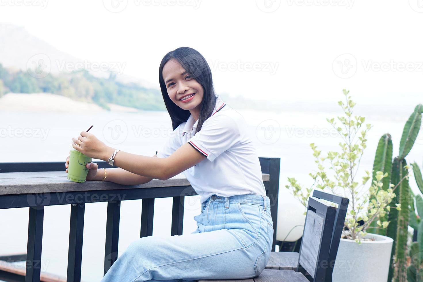 donna asiatica che sorride felicemente in un caffè foto