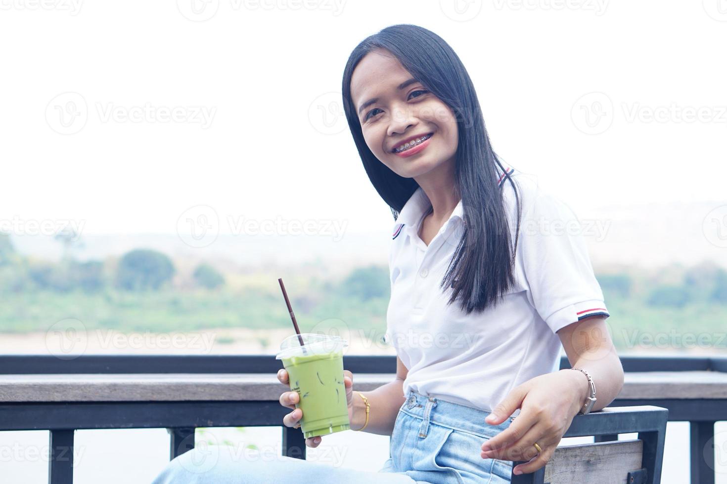 donna asiatica che sorride felicemente in un caffè foto