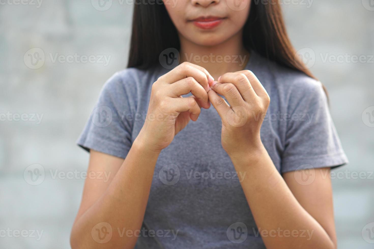 donna che graffia il braccio dal prurito su sfondo grigio chiaro. la causa del prurito della pelle include le punture di insetticoncetto di pelle sanitaria. foto