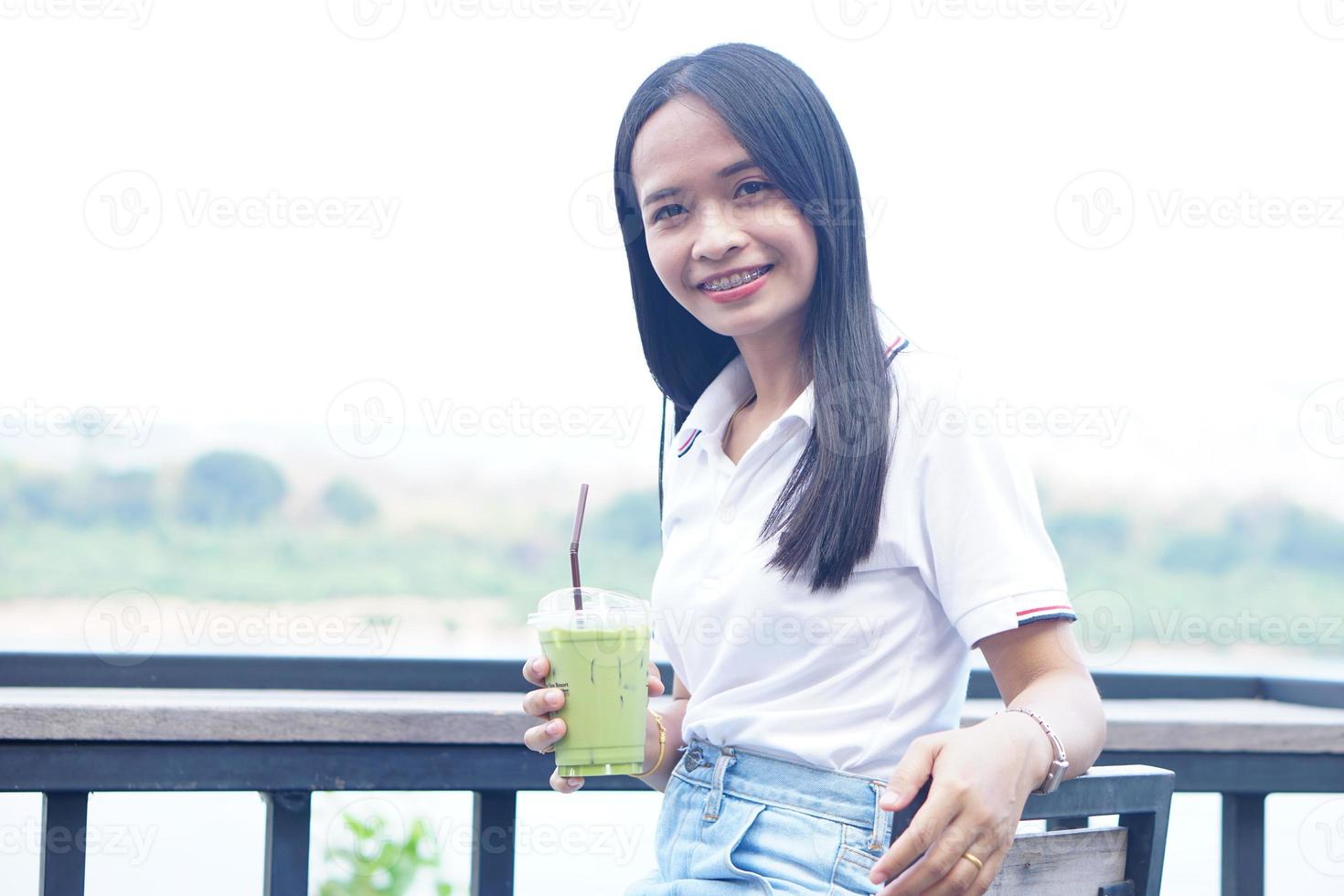 donna asiatica che sorride felicemente in un caffè foto