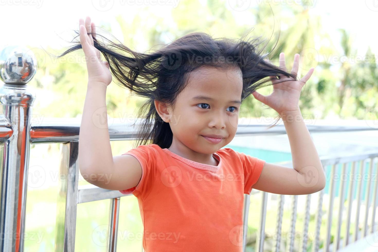 felice espressione bambina indonesiana con i capelli sciolti foto