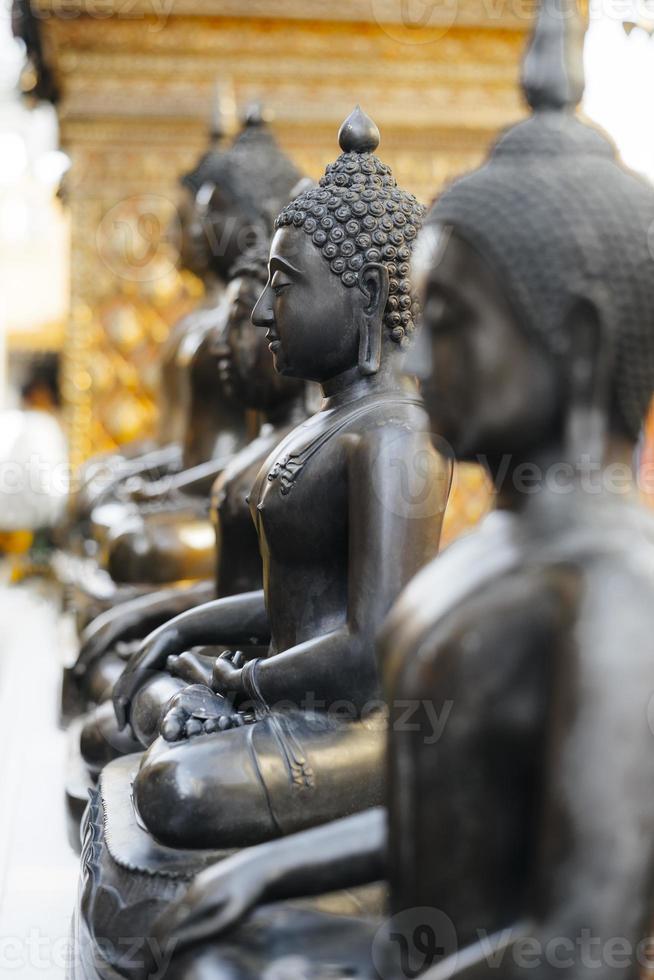 fila di statue buddiste in metallo scuro foto