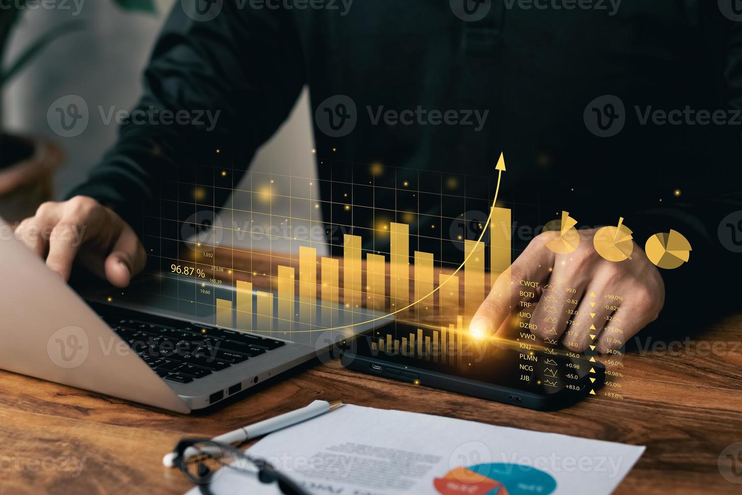 uomo d'affari che lavora con il dashboard virtuale di laptop e smartphone analizzando i dati sulle vendite finanziarie e il grafico della crescita economica. foto