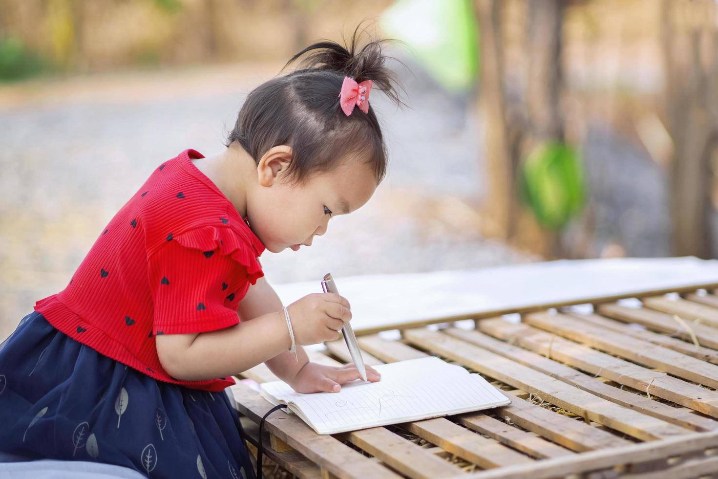 ragazza dei bambini che impara all'aperto foto