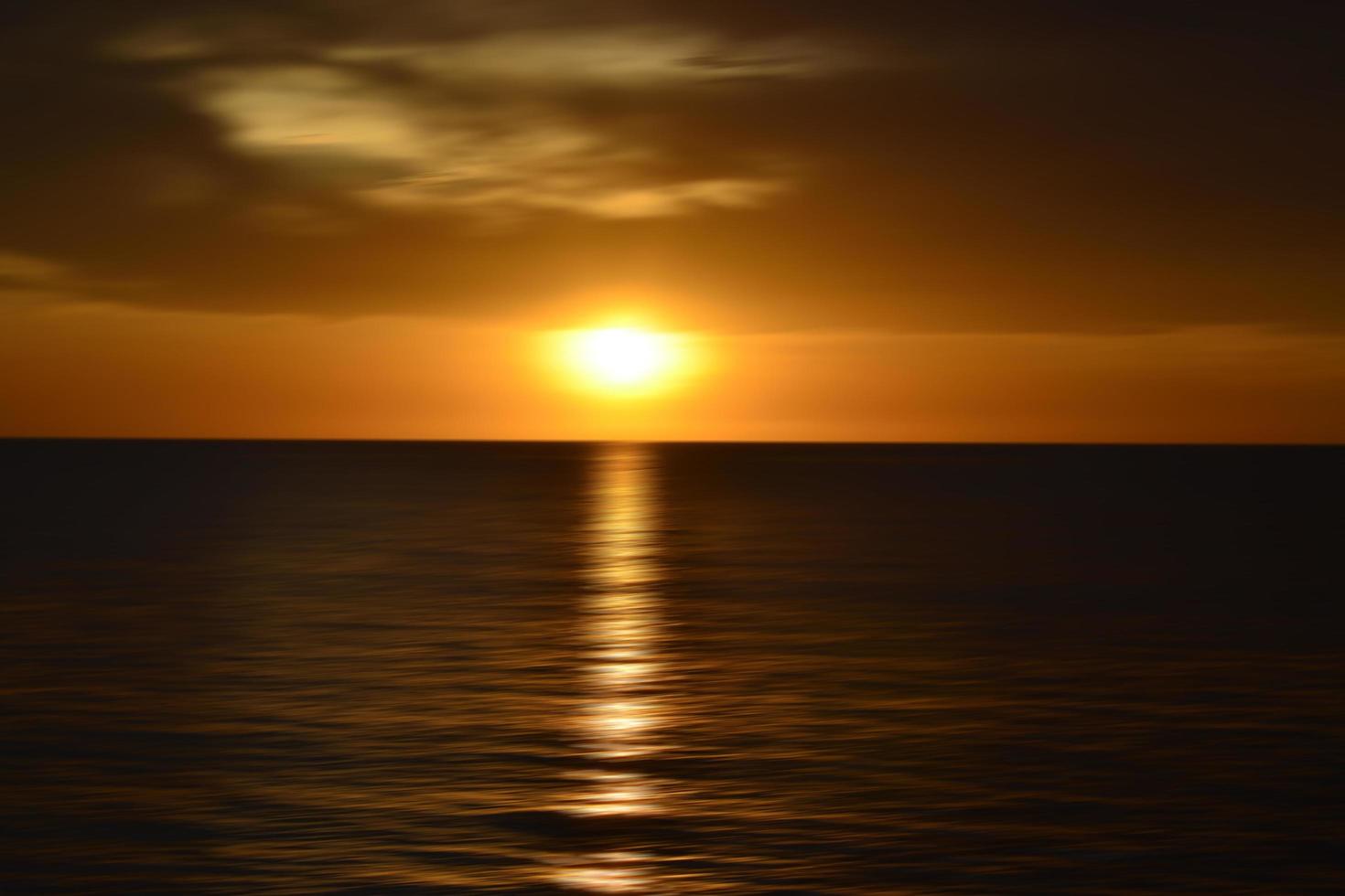 tramonto sull'oceano. sfondo sfocato di arte astratta in effetto movimento digitale. foto