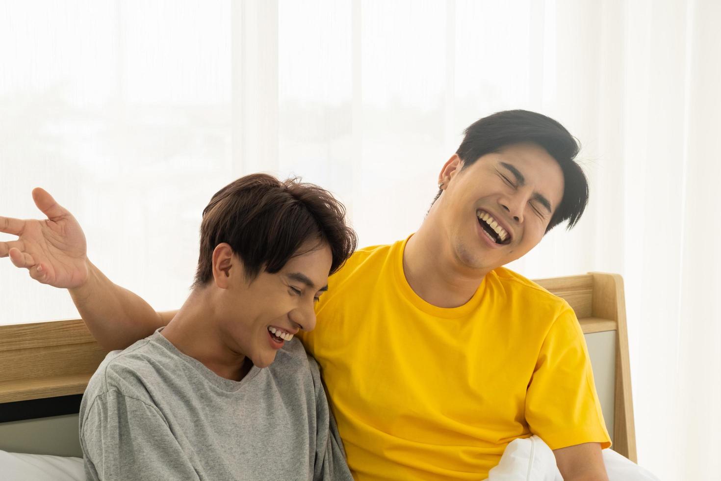 coppia omosessuale gay asiatica si abbraccia e si abbraccia sul letto. uguaglianza di genere e giusto concetto, momento giocoso e romantico. foto