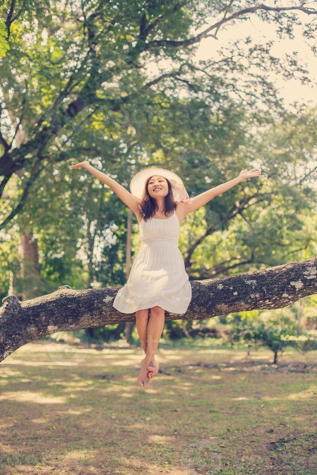 giovane ragazza teenager che si siede sull'albero foto