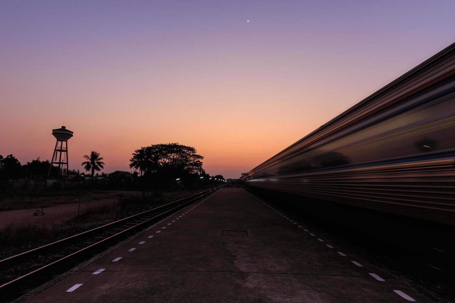 treno in movimento verso la stazione al tramonto foto