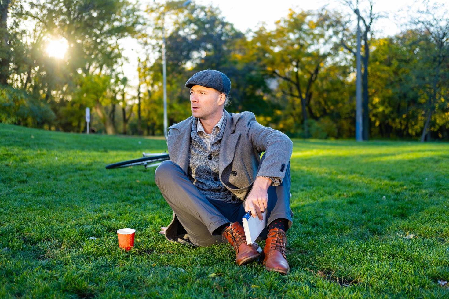 giovane maschio hipster leggere il libro nel parco autunnale foto