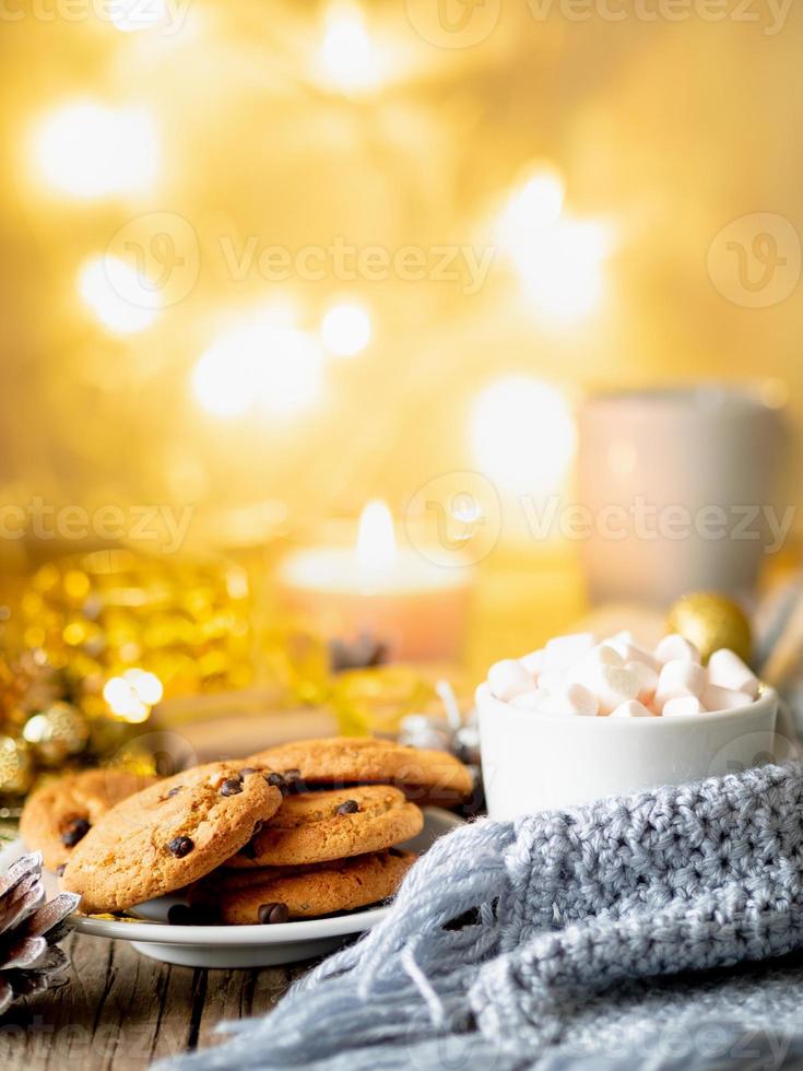 serata accogliente, tazza di bibita, decorazioni natalizie, candele e ghirlande di luci foto