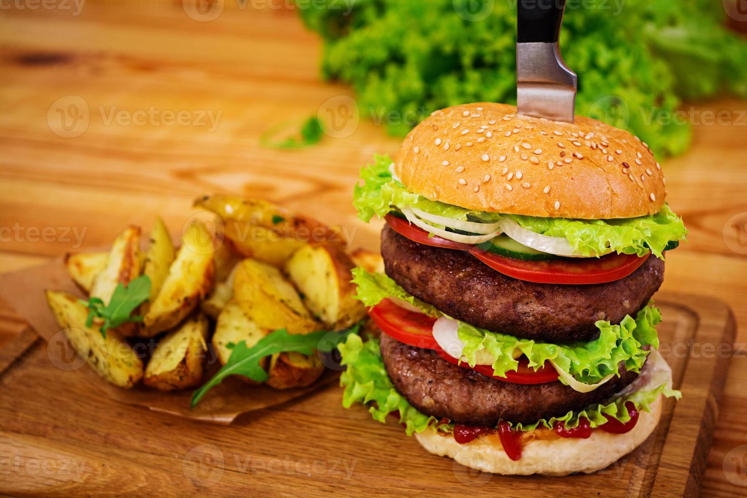 delizioso hamburger fatto a mano su fondo di legno. vista ravvicinata foto