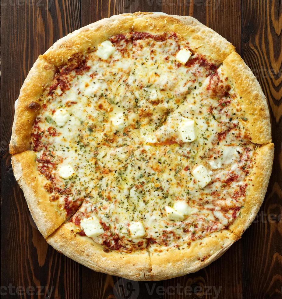 pizza ai quattro formaggi con dor-blue, parmigiano, feta, origano, mozzarella, salsa di pomodoro, vista dall'alto foto